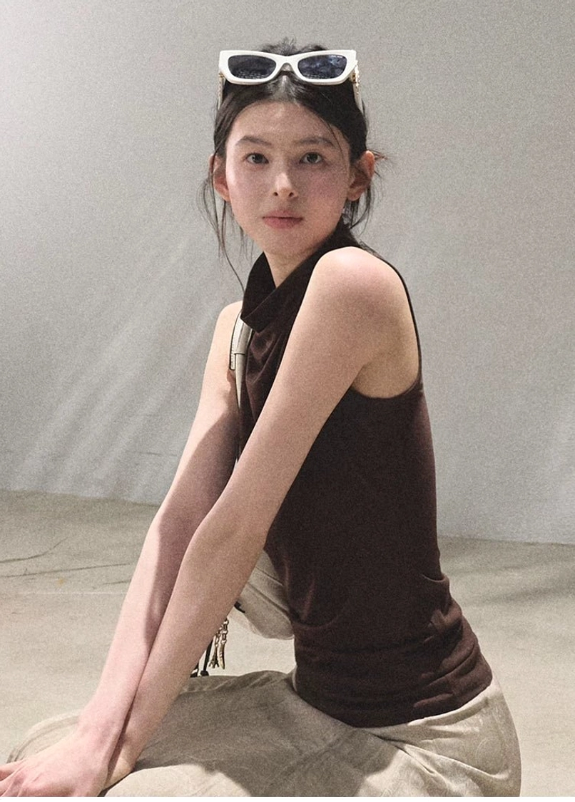 Mocha draped mock neck sleeveless slim fit top seated styling with relaxed khaki trousers