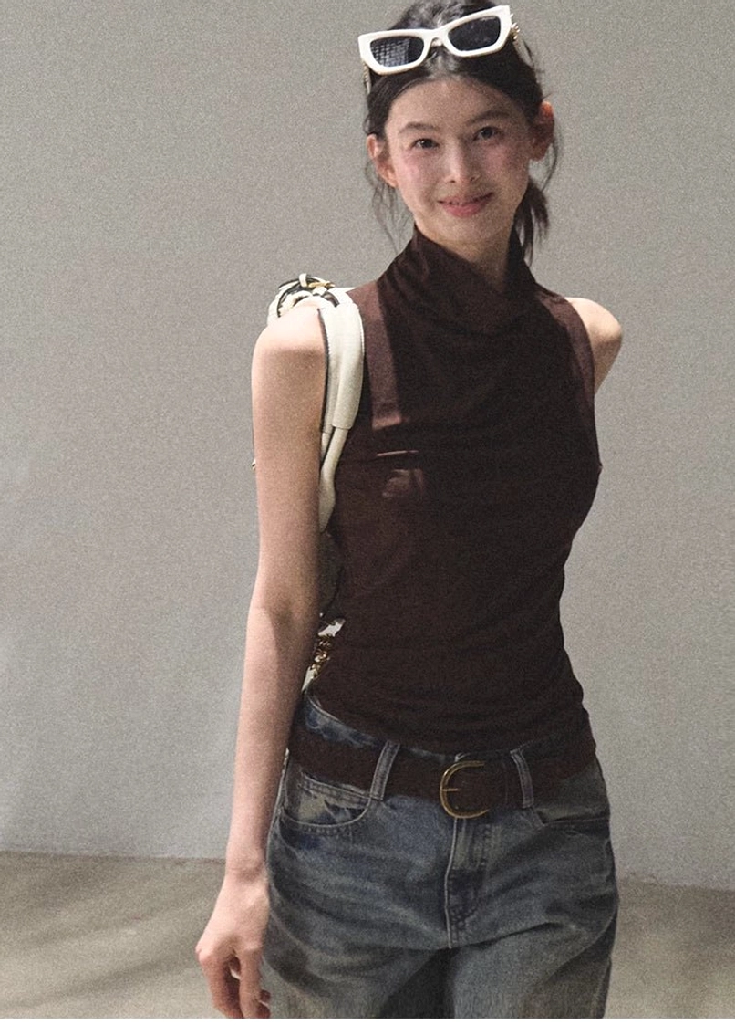 Front view of mocha draped mock neck sleeveless streetwear top with wide leg denim