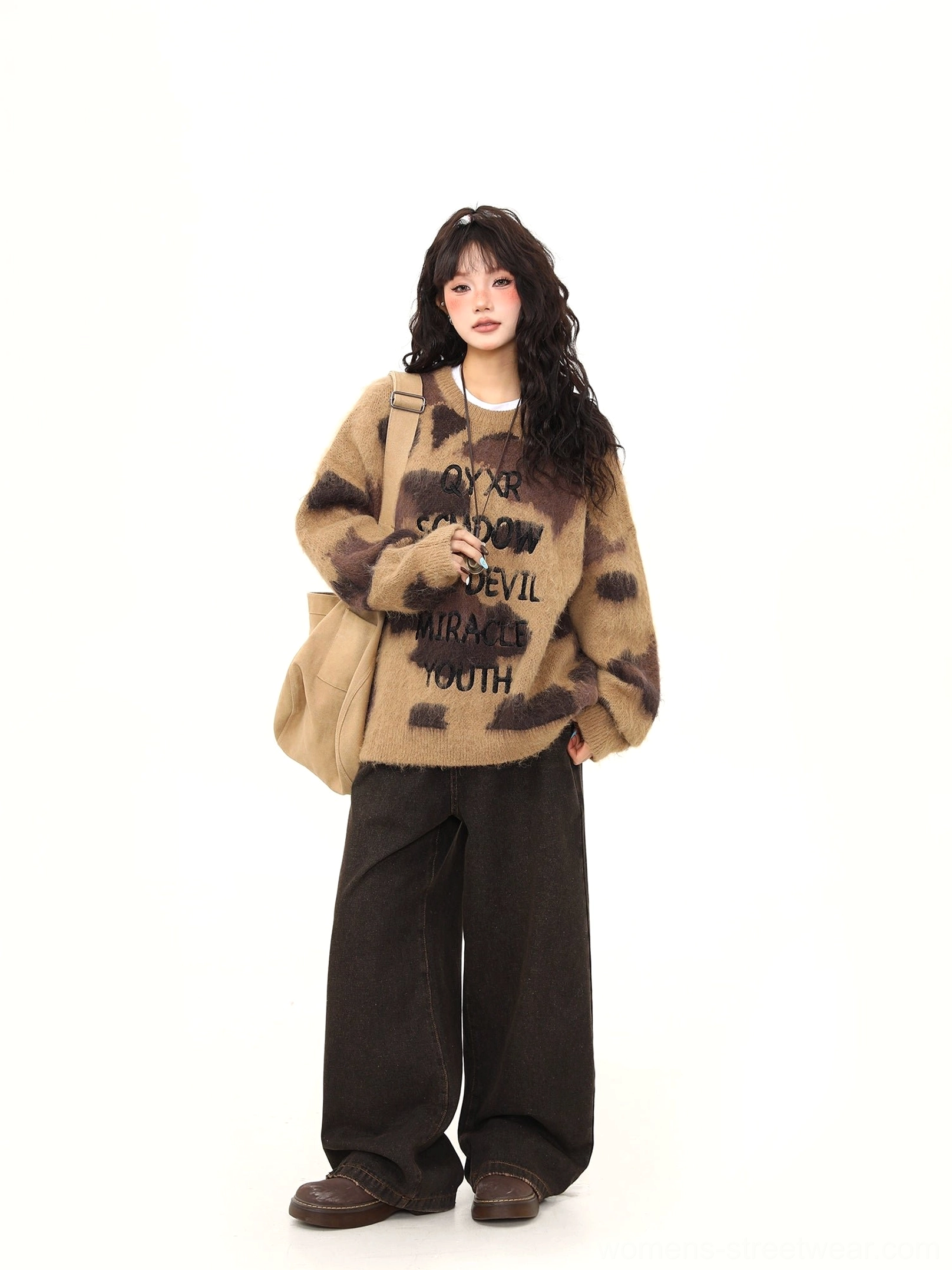Side front view of brown fuzzy oversized sweater with abstract animal print and black lettering