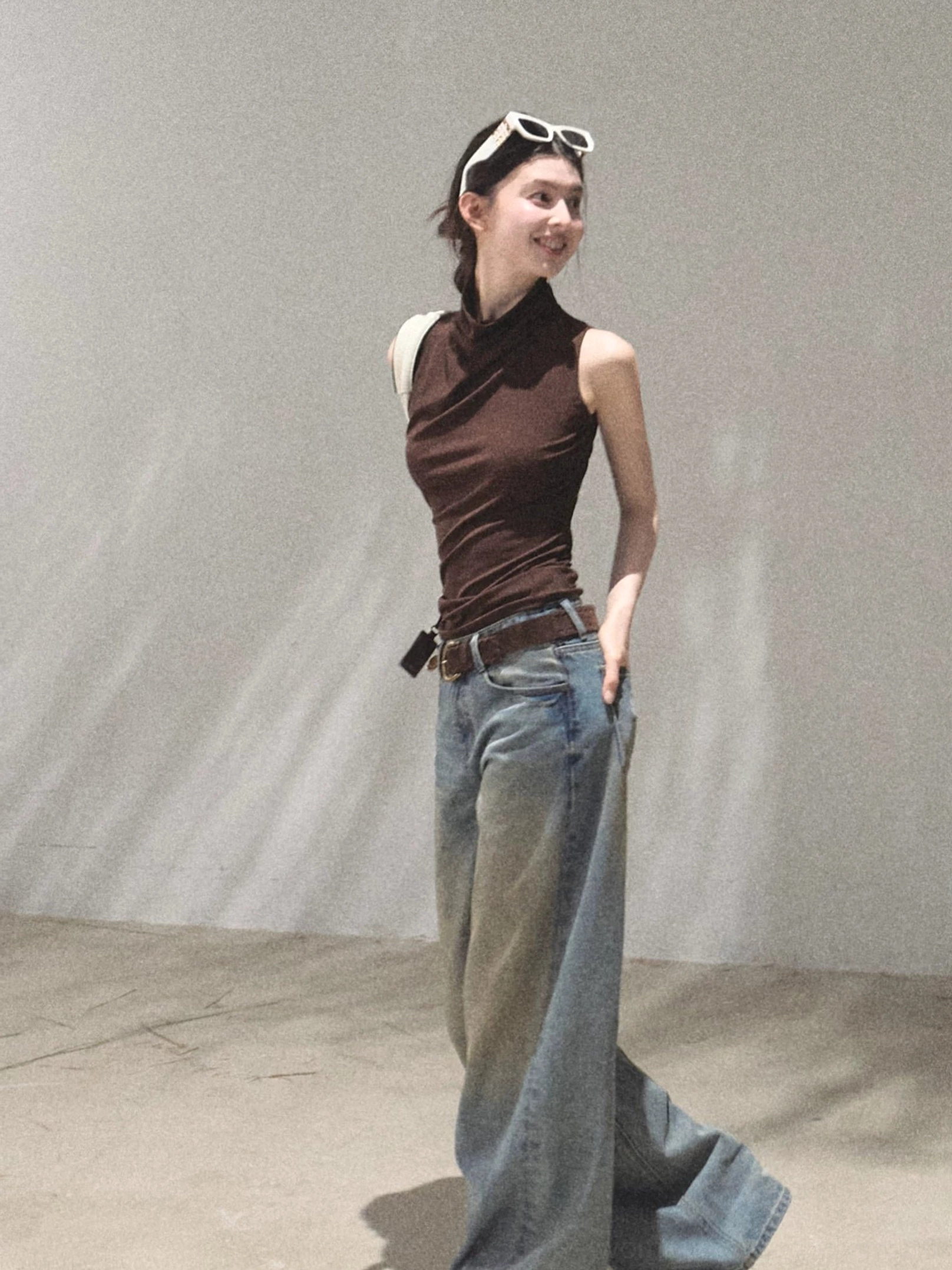 Mocha sleeveless mock neck slim fit top side profile styled with denim and leather belt