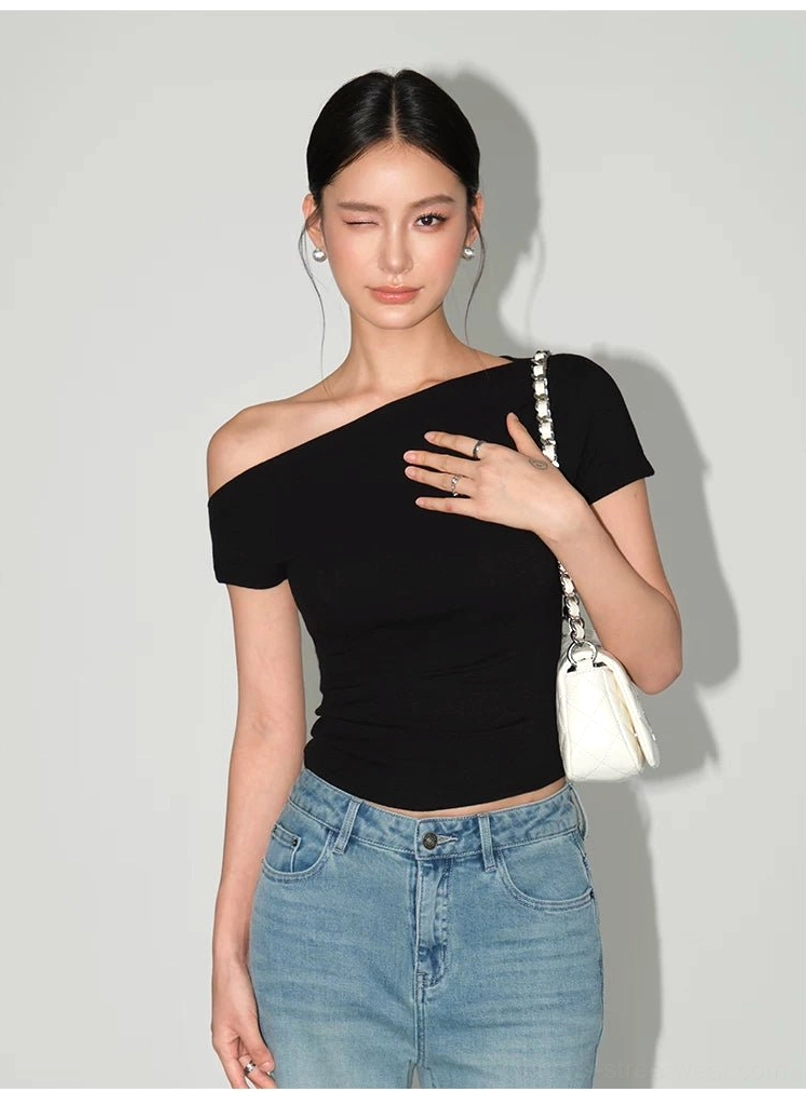 Modern asymmetric slim-fit tee showcasing the one-shoulder neckline, textured knit fabric, and hip-length hem