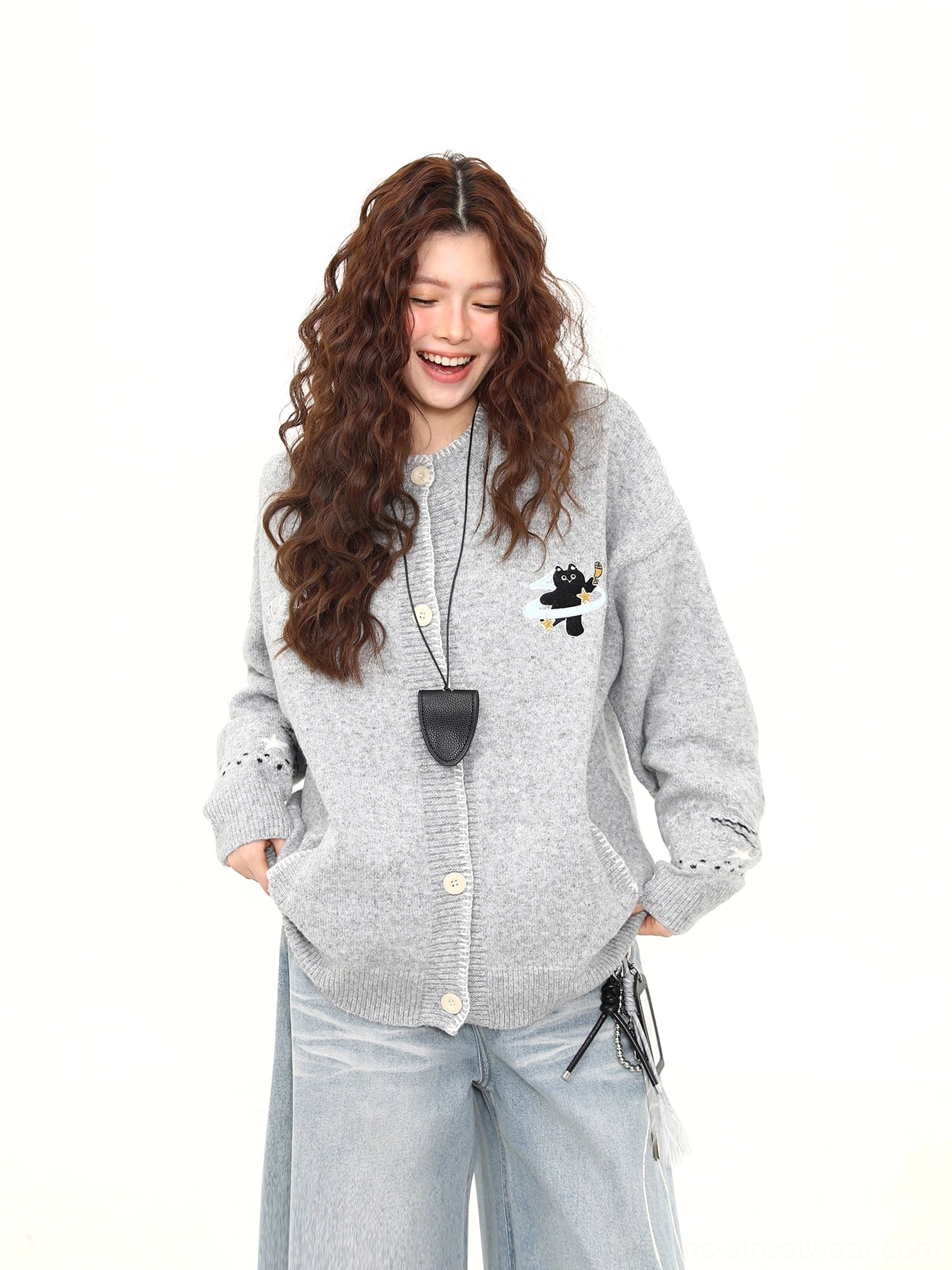 Relaxed oversized Moonlight Kitty cardigan worn with hands in pockets, featuring a button front, black cat embroidery, and ribbed knit construction