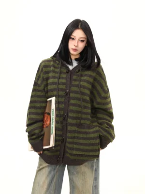 Front upper-body view of an oversized moss green and charcoal striped toggle knit hoodie cardigan with drop shoulders and soft fuzzy texture