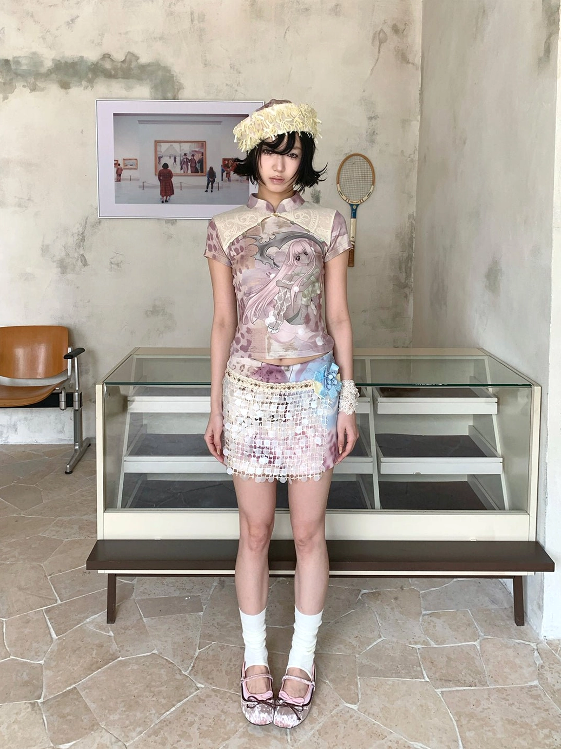 Full-body outfit featuring a multicolor anime graphic cheongsam collar tee, beaded mini skirt, white socks, and leather flat sandals