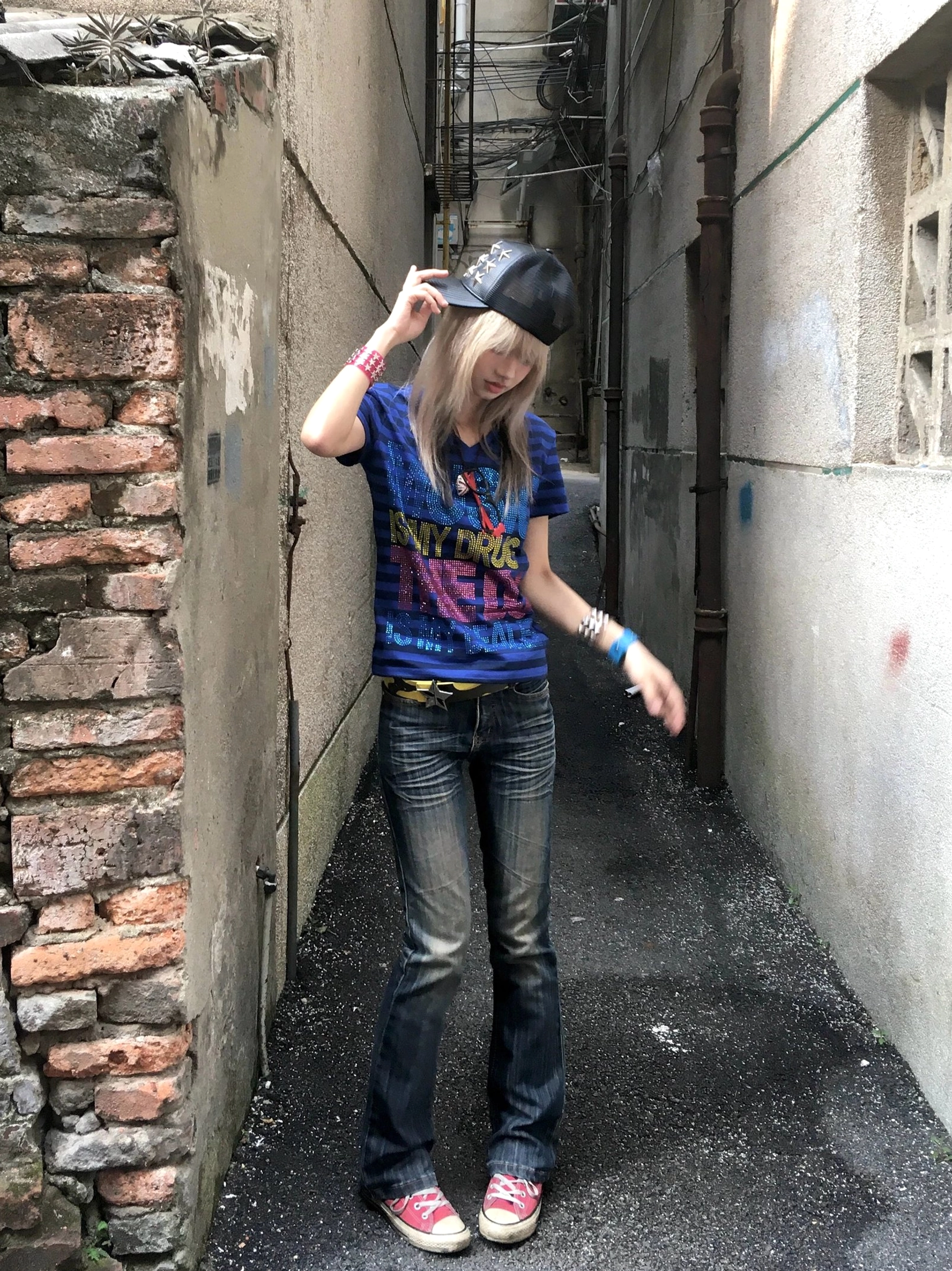 Side view of fitted deep blue and navy striped rhinestone V-neck streetwear tee on model
