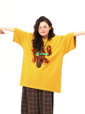 Mustard retro double-figure oversized graphic streetwear tee front full-body view styled with brown plaid wide-leg pants