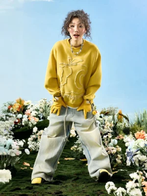 Mustard yellow abstract embroidered oversized crewneck sweatshirt shown in a full-body casual streetwear outfit