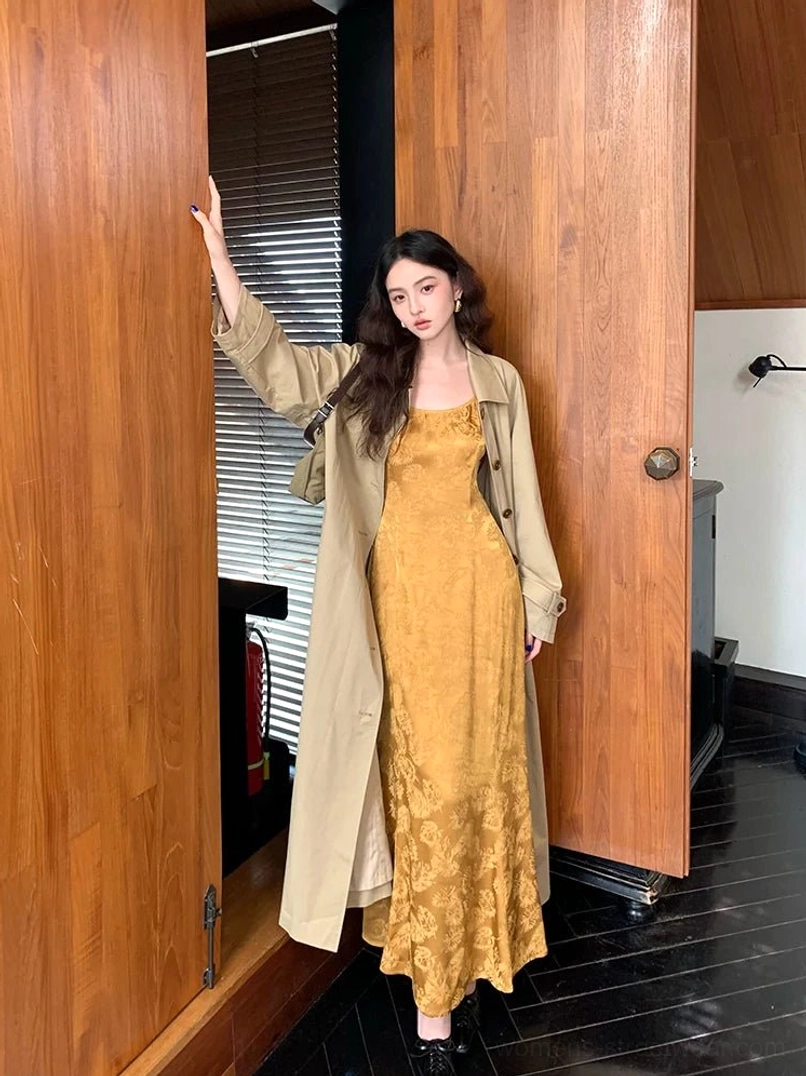 Mustard yellow floral jacquard satin slip dress styled with a khaki trench coat and black leather shoes