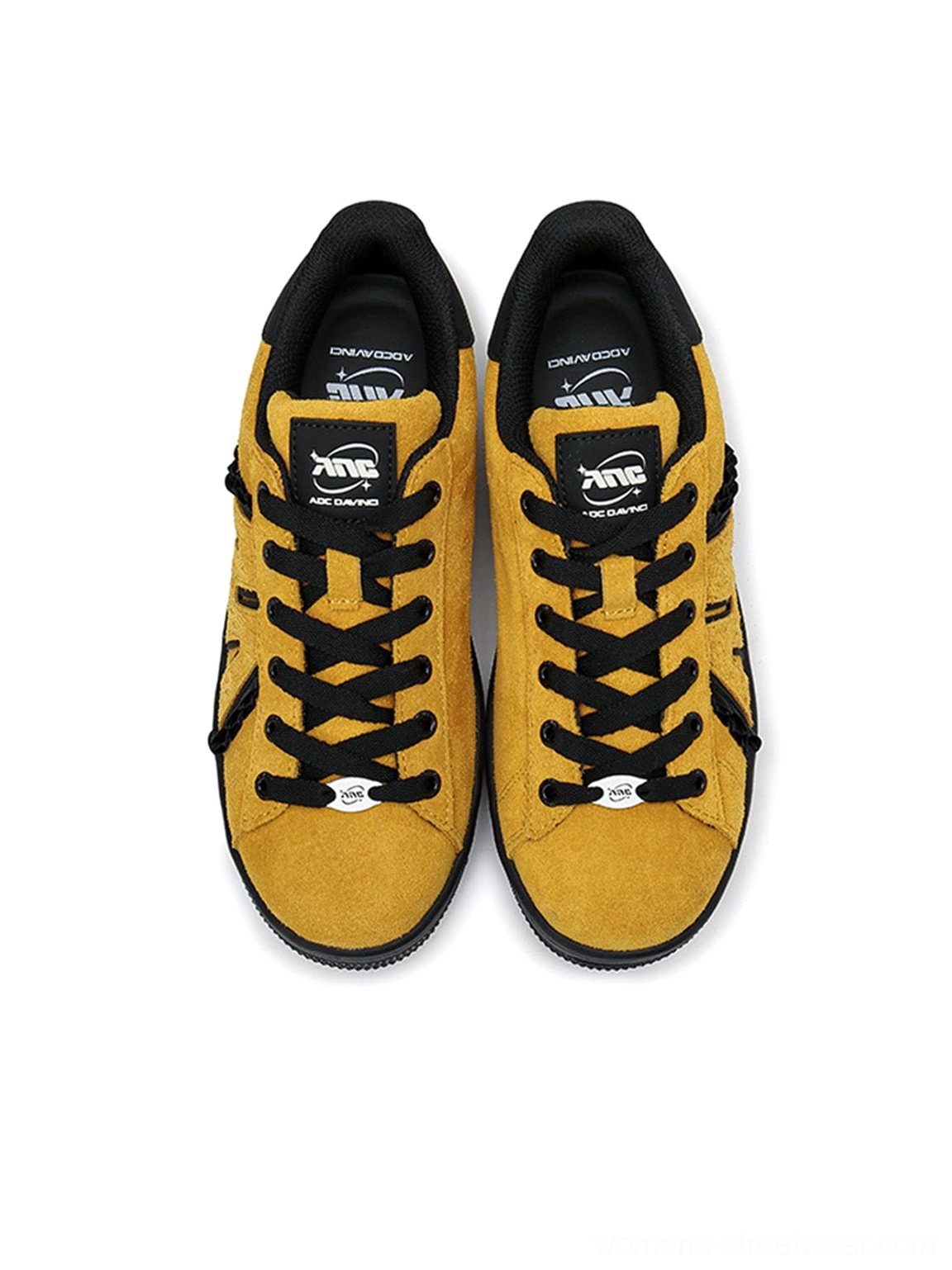 Top view of mustard yellow suede platform sneakers with black laces, black tongue, and cushioned insoles