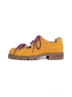 Mustard yellow suede-look workwear derby shoes with purple braided laces, decorative brogue perforations, and chunky lug rubber soles shown in side profile