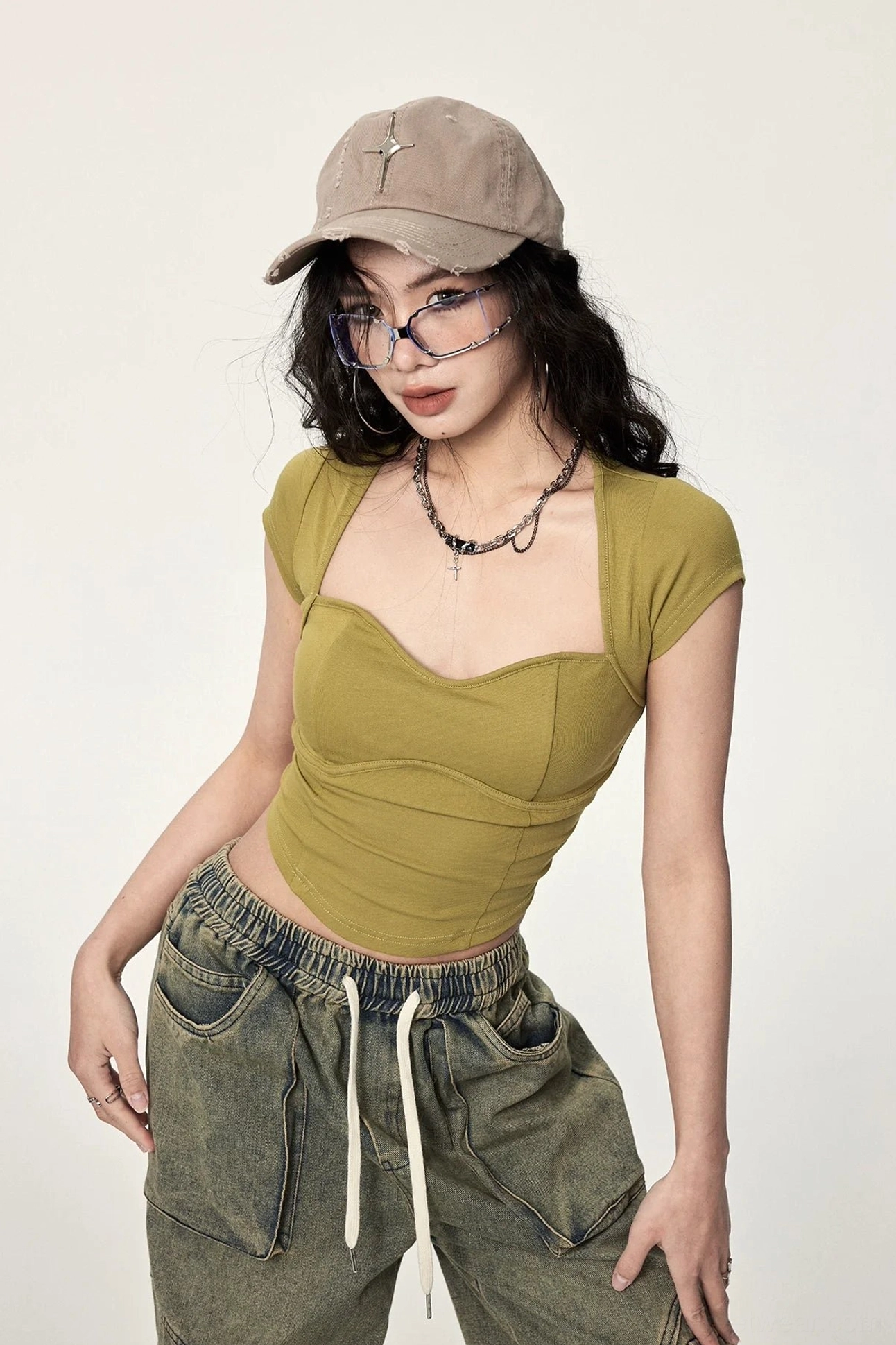 Front three-quarter view of mustard yellow sweetheart neckline cropped top with curved seams, fitted shape, cap sleeves, and wide leg jeans