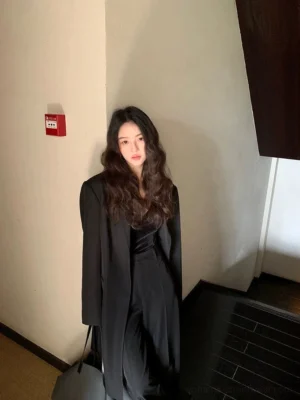 Mystic black oversized mid-length blazer worn over a satin camisole in an indoor setting, relaxed Korean fashion tailored outfit