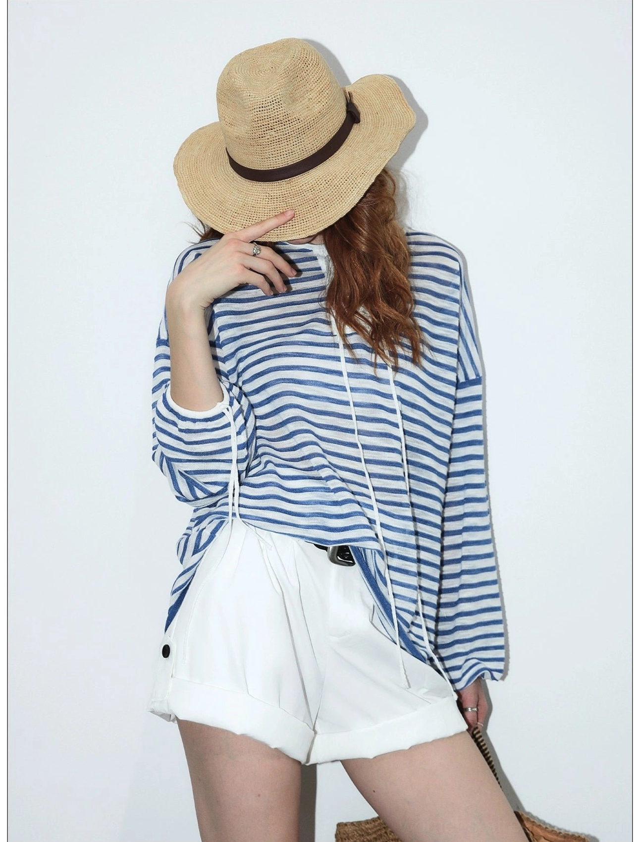 Back detail of blue and white striped nautical long sleeve top with relaxed drape and white high-waisted shorts