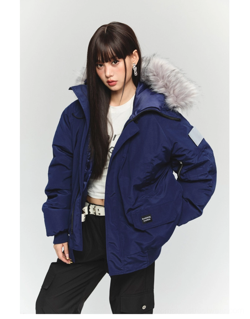Three-quarter side view of a navy blue faux fur hooded winter parka styled with a cropped top and cargo pants in Seoul streetwear style