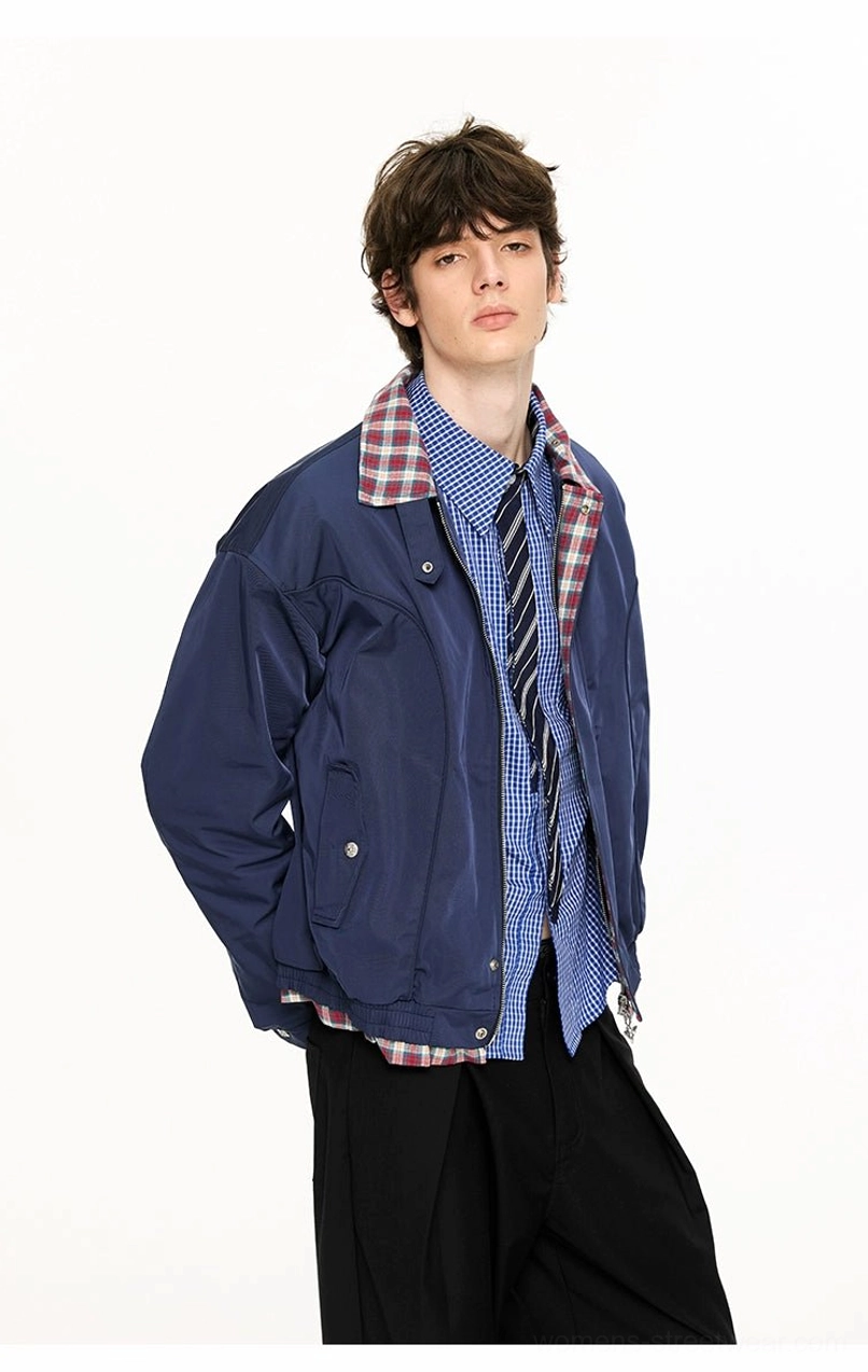 Three-quarter side view of navy blue Harrington jacket showing relaxed cropped fit plaid lining and layered streetwear styling