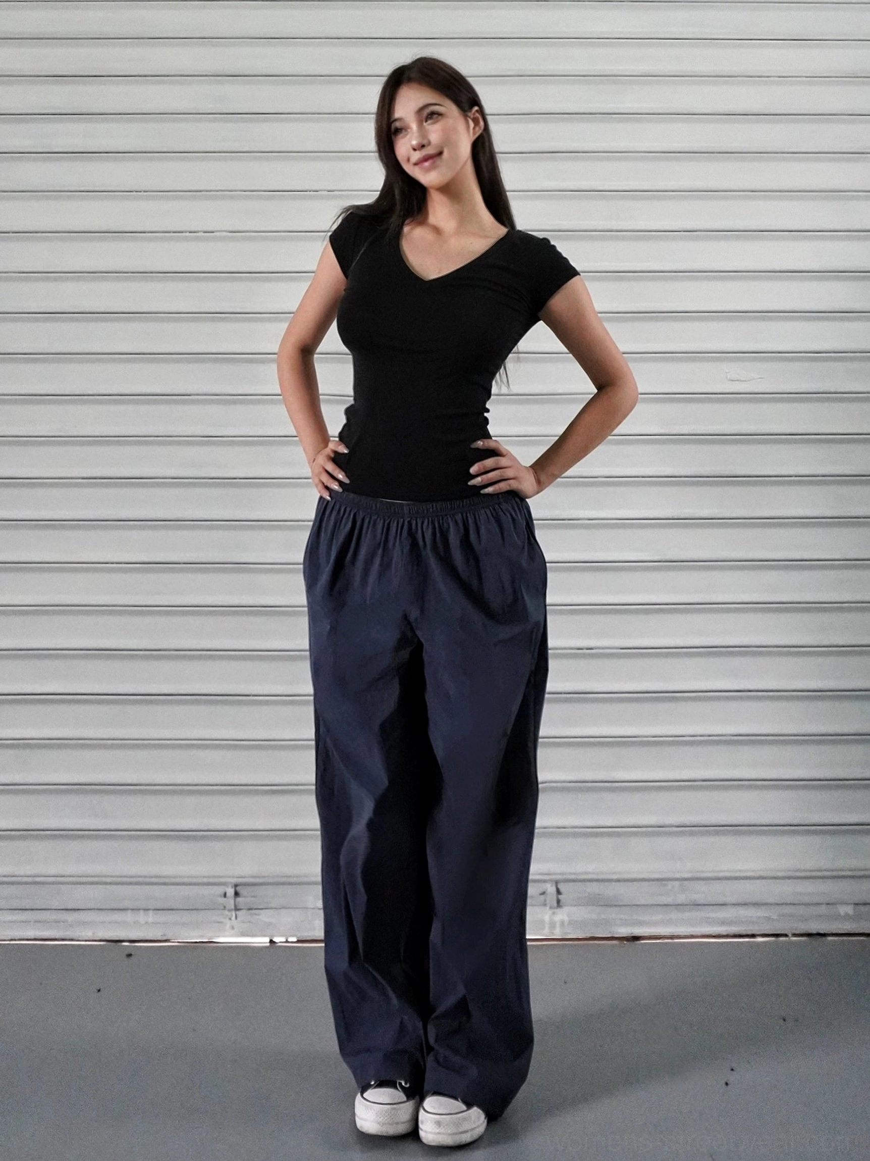 Navy blue low-rise wide-leg athletic cargo pants styled with a black cropped short-sleeve top