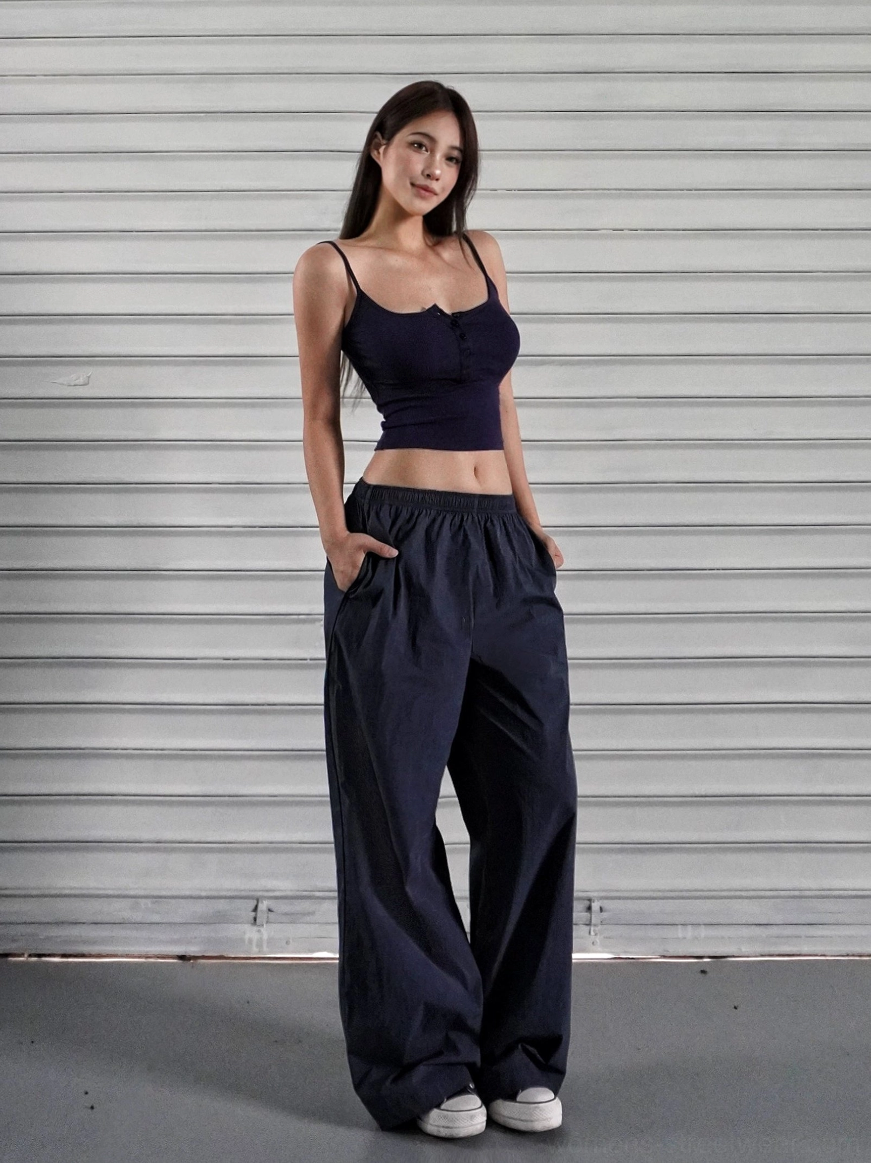 Navy blue low-rise wide-leg streetwear cargo pants with a dark purple cropped camisole and side pockets