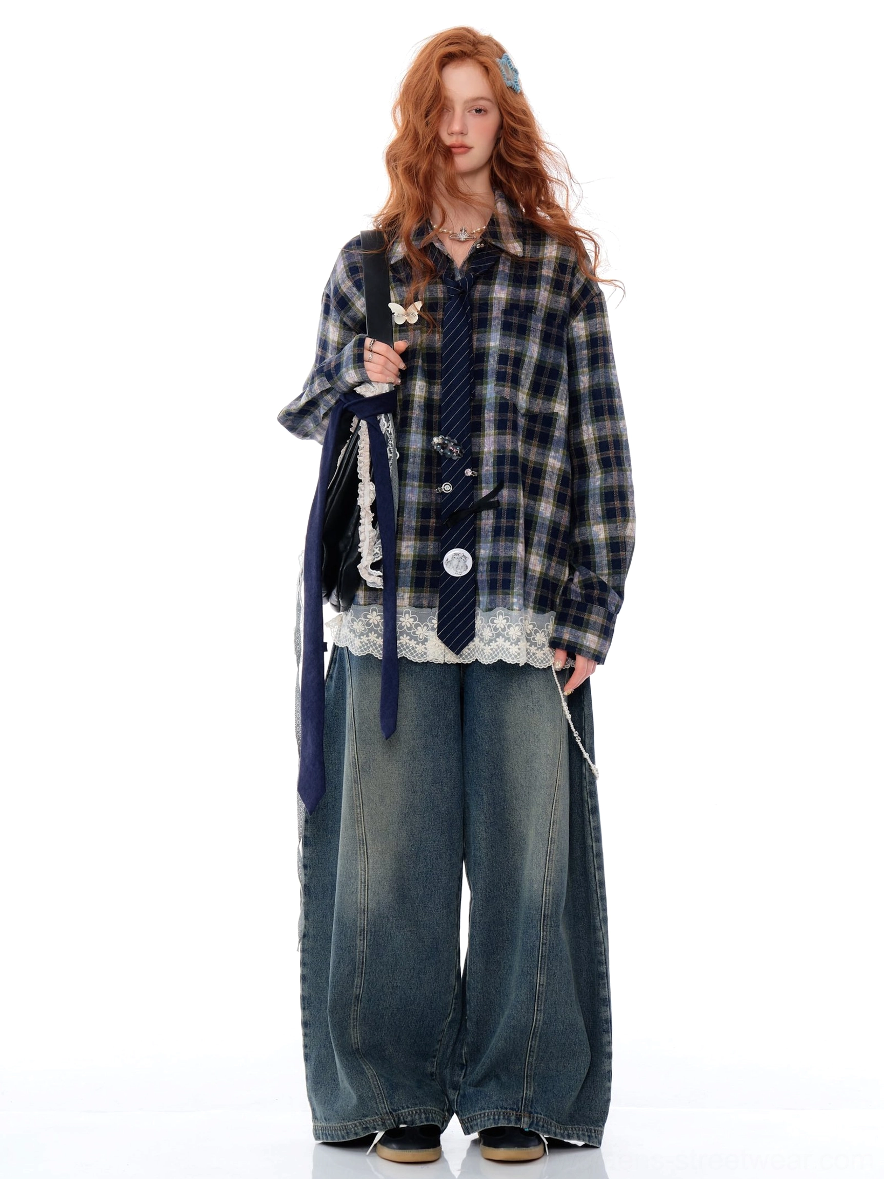 Full body view of a navy blue plaid lace trim shirt paired with wide-leg denim and a matching decorative necktie