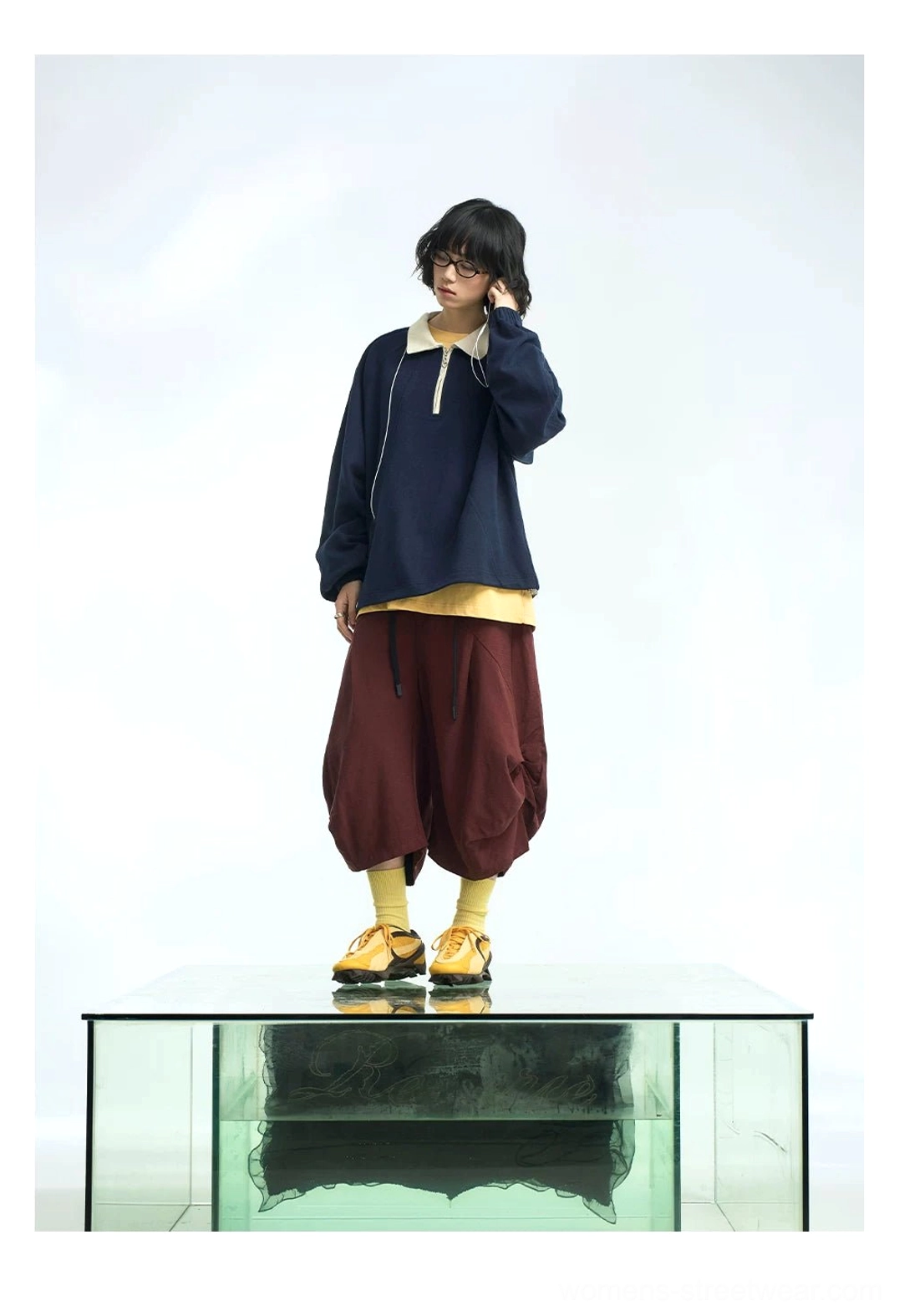 Navy blue quarter-zip polo pullover layered with a yellow shirt and burgundy cropped cargo pants