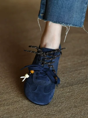 Navy blue suede streetwear sneaker worn with frayed cropped raw hem denim and decorative beaded shoelaces