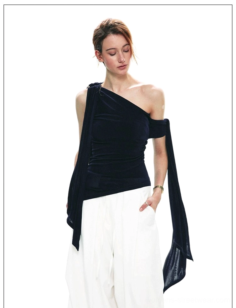 Front three-quarter view of a navy blue velvet one-shoulder top with long side sash styled for contemporary Korean streetwear
