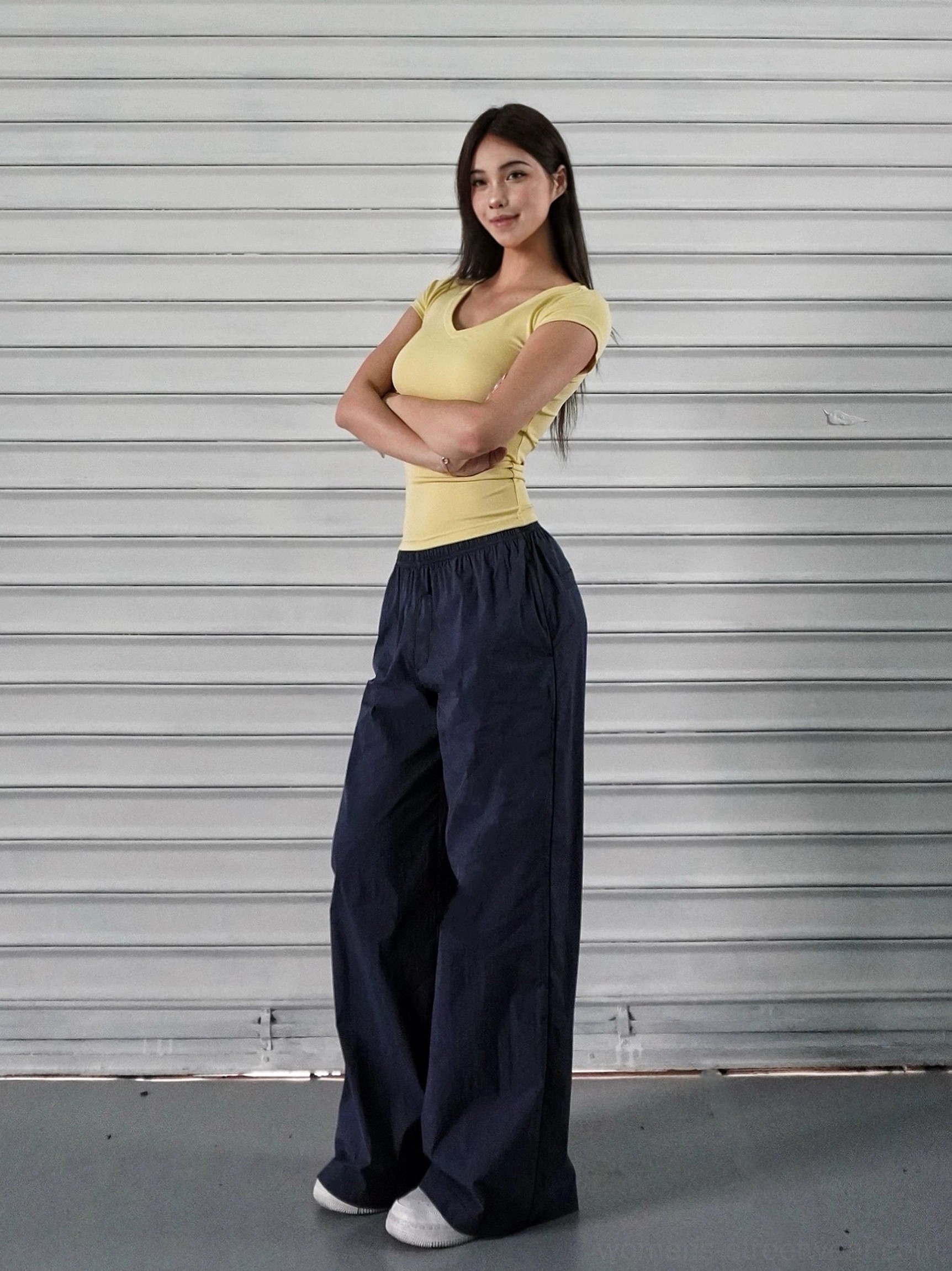 Navy blue wide-leg cargo pants styled with a yellow cropped short-sleeve top in a modern urban outfit