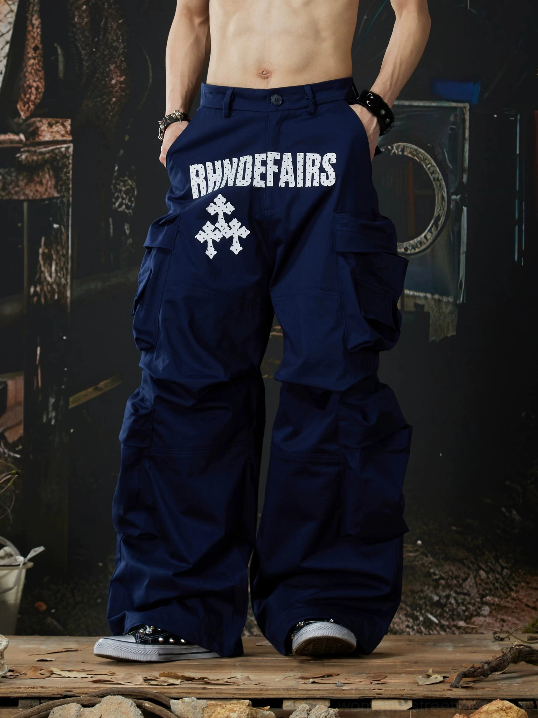 Navy blue wide-leg streetwear cargo pants back three-quarter view showing layered side utility pockets and relaxed silhouette