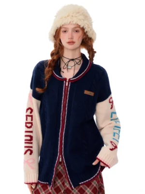 Front view of a navy colorblock varsity knit cardigan with off-white sleeves, red zipper trim, embroidered lettering, and relaxed oversized fit