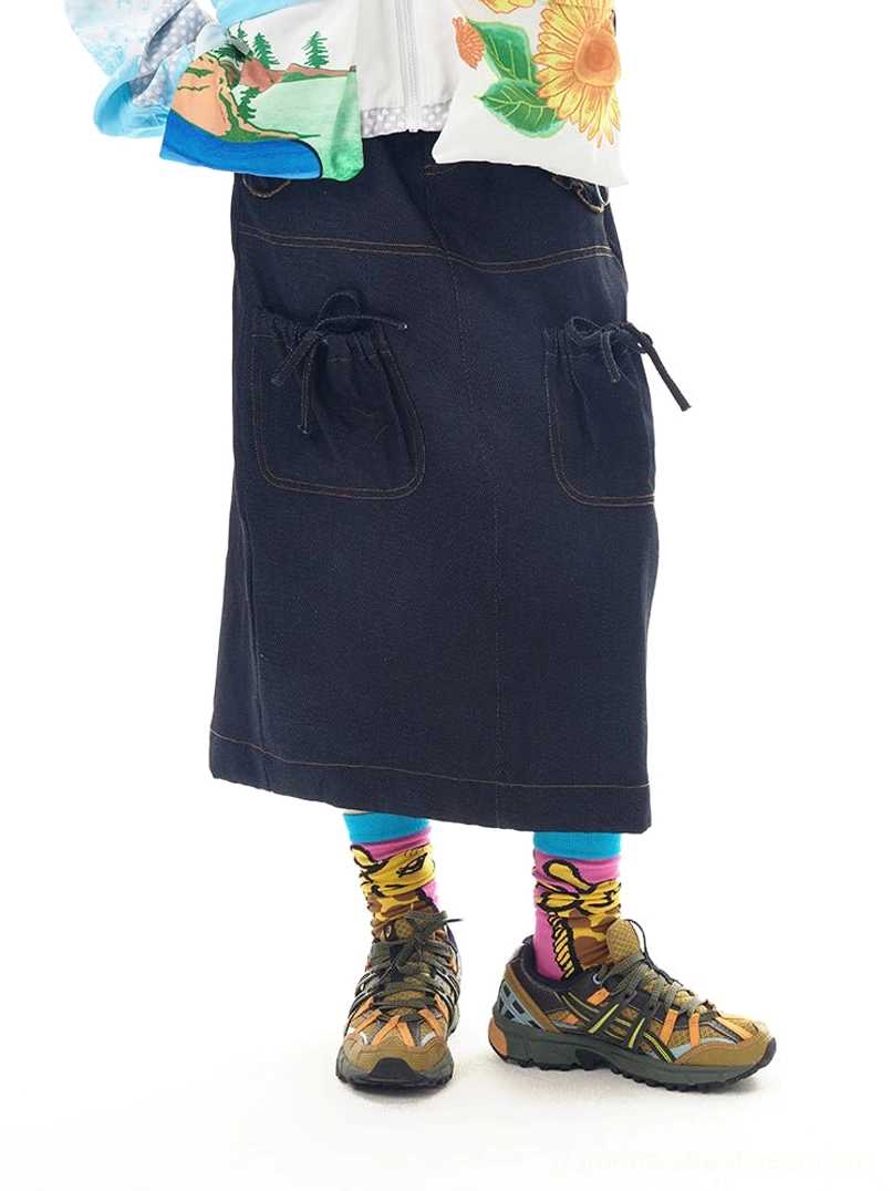 Navy denim utility pocket midi skirt back three-quarter model view showing rear pockets side drawstrings and contrast stitching