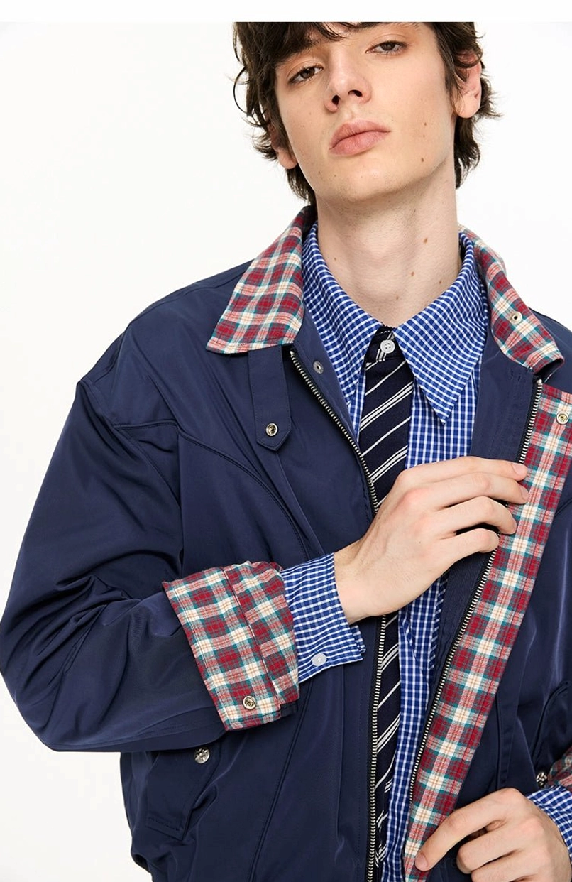 Close-up of navy blue Harrington jacket collar cuffs and snap hardware revealing the contrasting plaid lining
