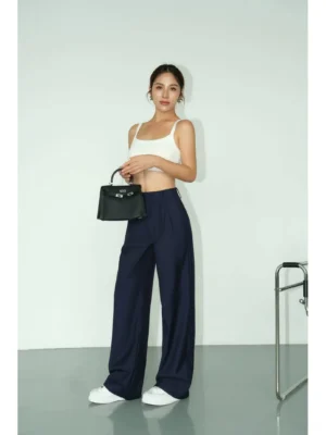 Side-front view of deep navy high-waist wide-leg tailored streetwear trousers with a relaxed draped silhouette