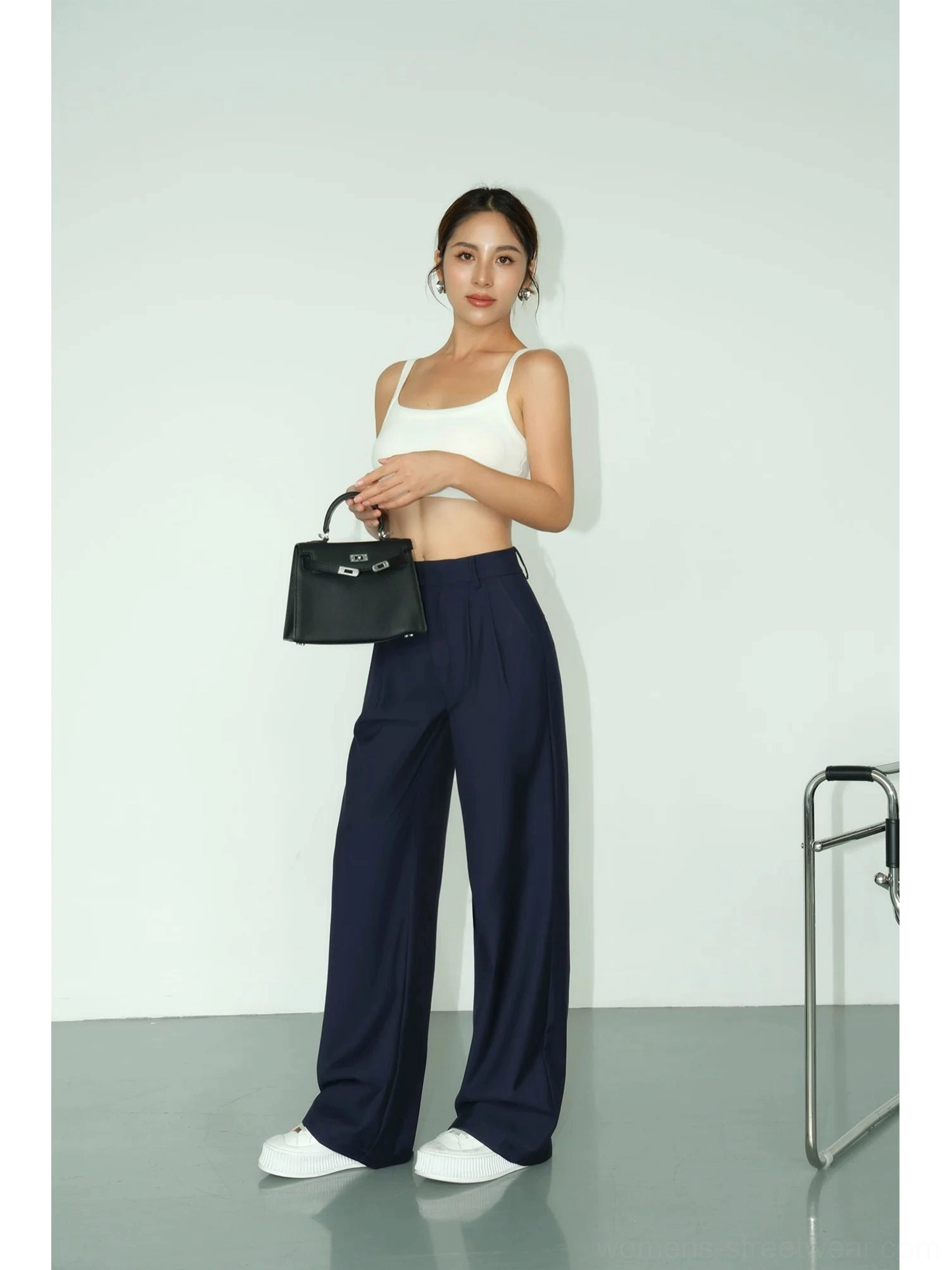Side-front view of deep navy high-waist wide-leg tailored streetwear trousers with a relaxed draped silhouette