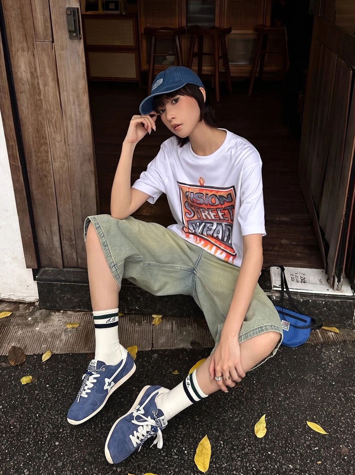Navy low-profile suede panel sneakers styled with cargo shorts, striped crew socks, and a graphic tee