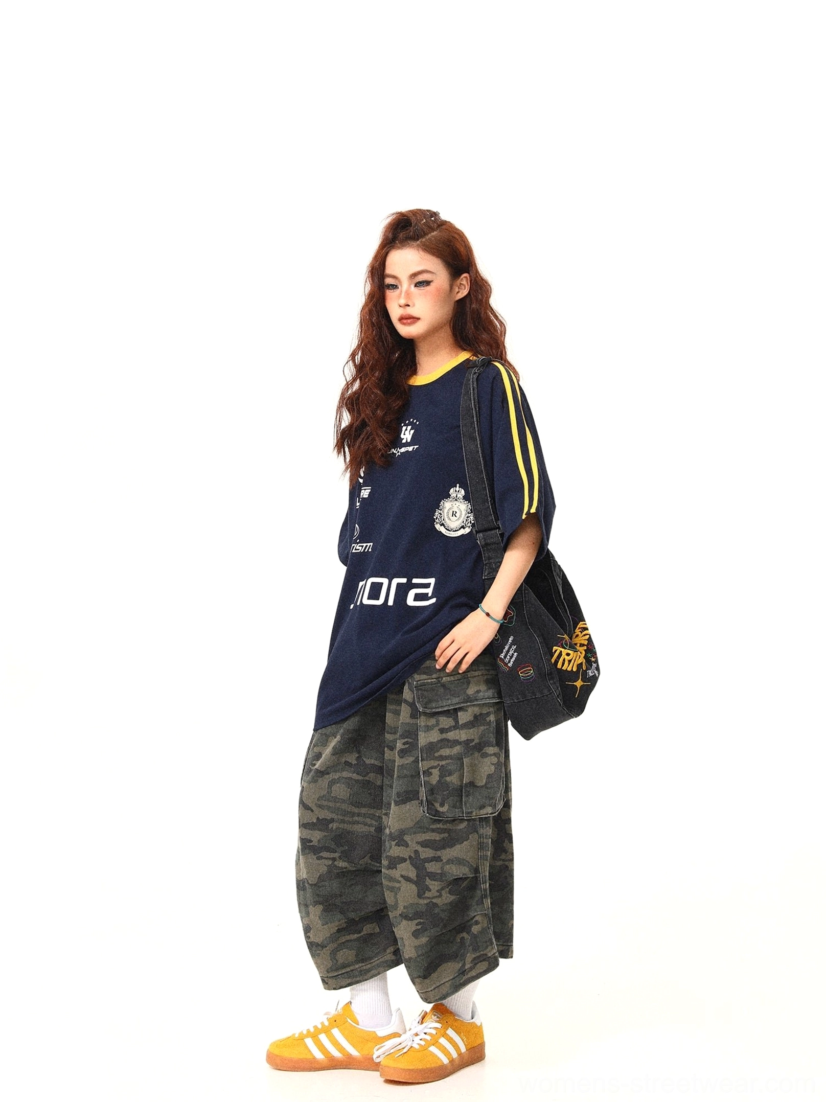 Side view of navy oversized retro sporty graphic t-shirt showing relaxed silhouette and yellow sleeve stripe detail
