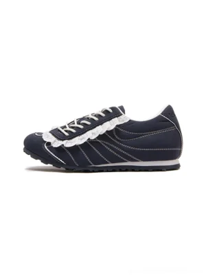 Dark navy low-profile streetwear trainer in side profile with white contrast stitching and decorative ruffled lace trim