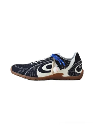 Navy swirl-panel low-profile trainers with cream white overlays, cobalt blue laces, baseball pendant, and gum rubber sole