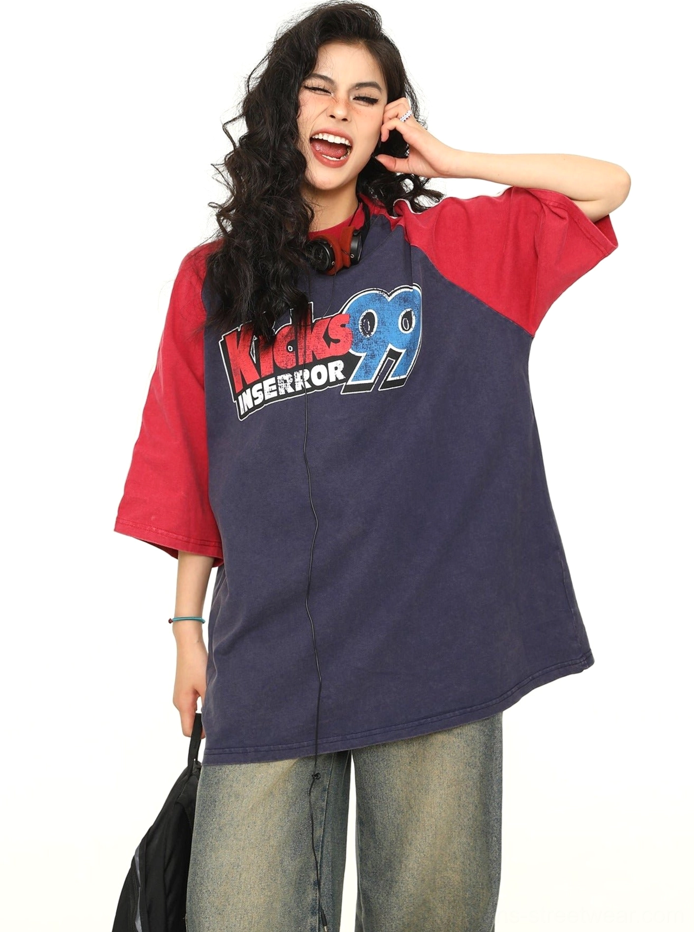 Three-quarter view of a navy varsity raglan graphic T-shirt with red sleeves and vintage athletic chest lettering