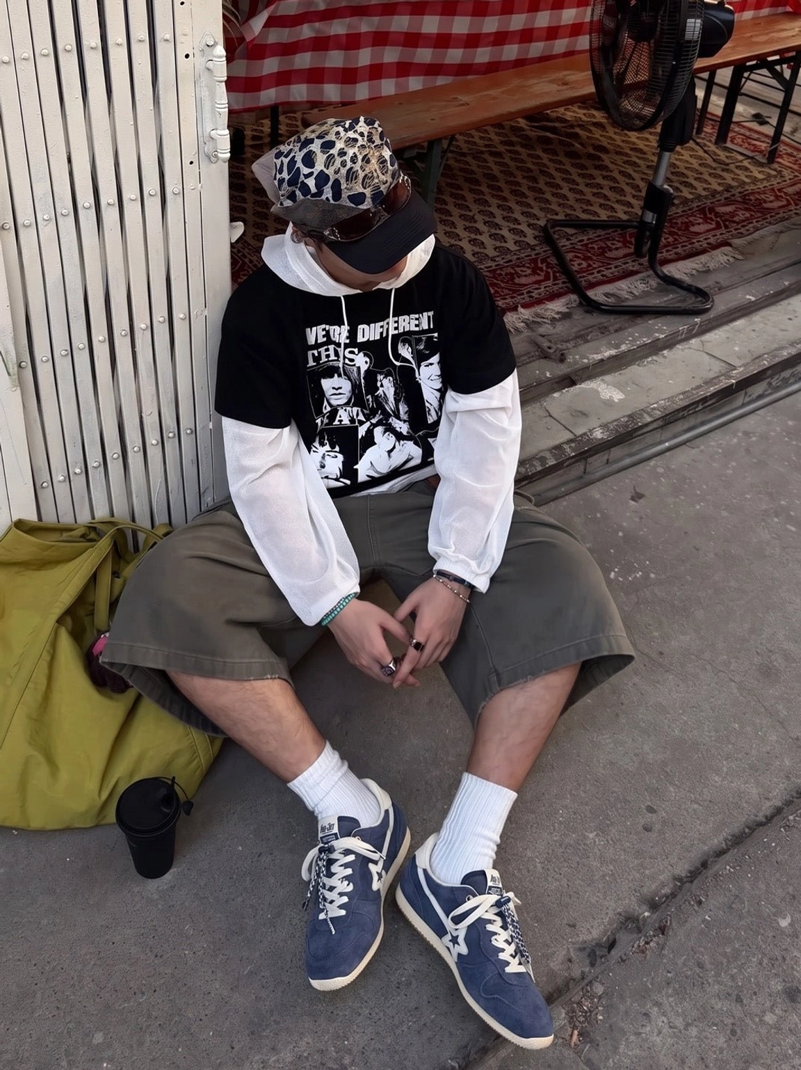 Navy blue retro suede trainers worn with cargo shorts, graphic layers, and a bucket hat in a casual streetwear outfit
