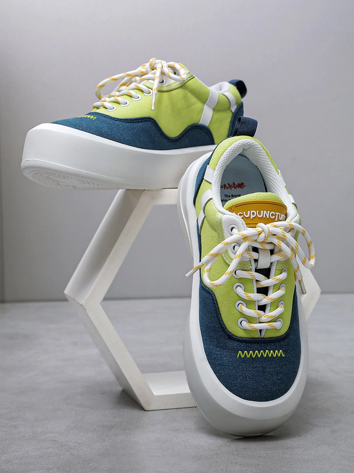 Angled neon colorblock canvas sneaker display with chunky white platform sole decorative toe stitching and tongue detail
