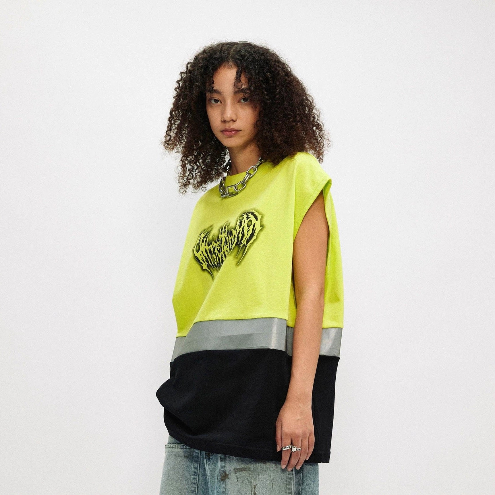 Close front view of fluorescent lime oversized gothic graphic tank top with black lower panel and silver reflective stripe
