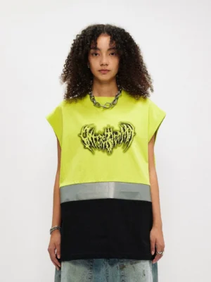 Female model wearing a fluorescent lime and black oversized gothic graphic tank top with reflective silver stripe and loose denim