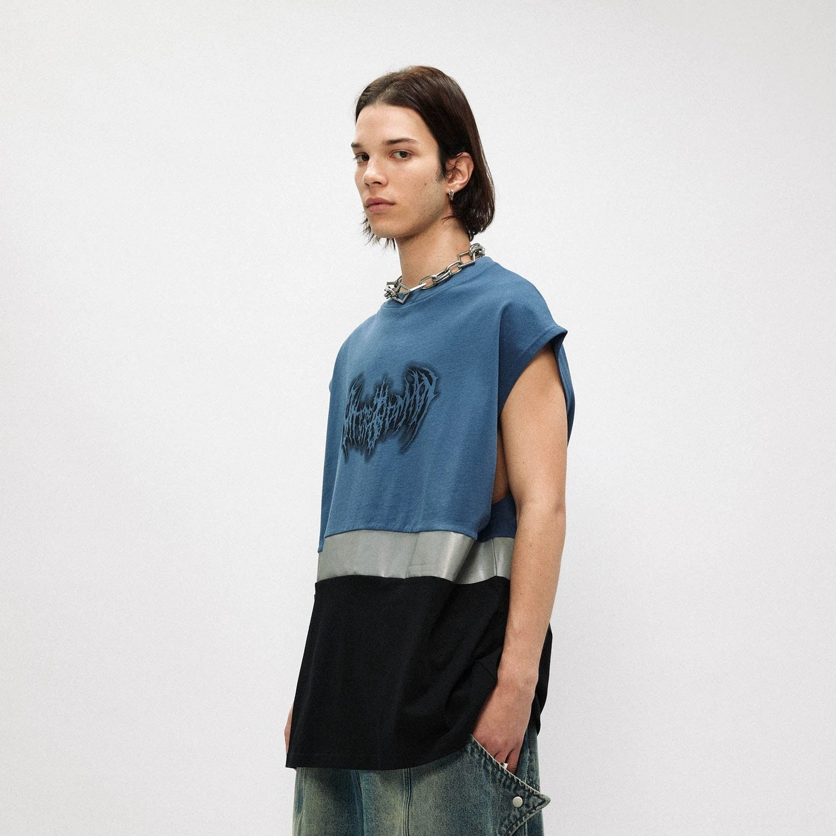 Side view of dusty blue and black oversized sleeveless streetwear tank top showing reflective stripe and open armholes