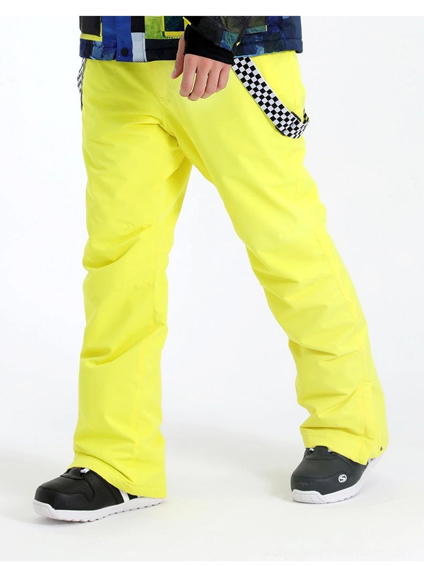 Model wearing neon yellow checkerboard strap snow pants with a printed ski top and black sport shoes