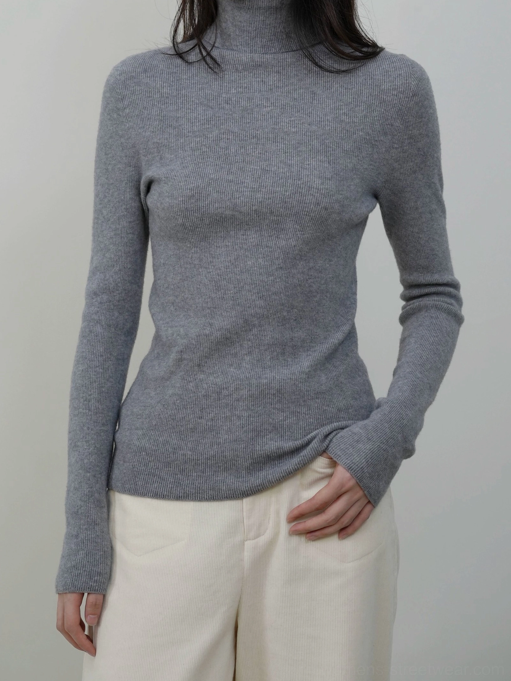 Neutral light gray solid mock neck knit sweater with a smooth finish paired with off white trousers