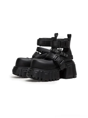 Pair of black buckled platform boots with adjustable side straps, metal hardware, chunky lug soles, and alternative streetwear design