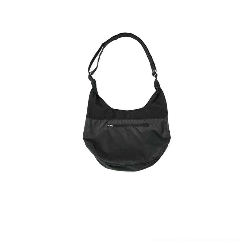 Compact matte black utility sling hobo bag back view with hidden zipper pocket and adjustable metal buckle shoulder strap
