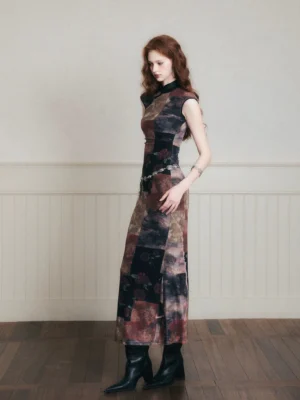 Side view of fitted noir floral patchwork cheongsam-inspired maxi dress styled with black heeled ankle boots