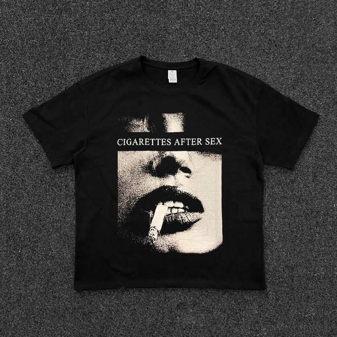 Black Noir Reverie halftone band graphic tee with vintage smoking lips portrait print and relaxed cropped streetwear silhouette shown in a flat lay