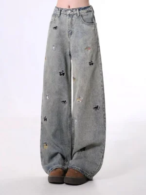 Nostalgic blue vintage washed wide leg denim jeans with scattered dog embroidery front full length view