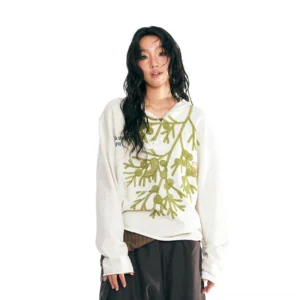 Front view of oatmeal embroidered leaf v-neck oversized pullover styled with dark brown wide-leg pants
